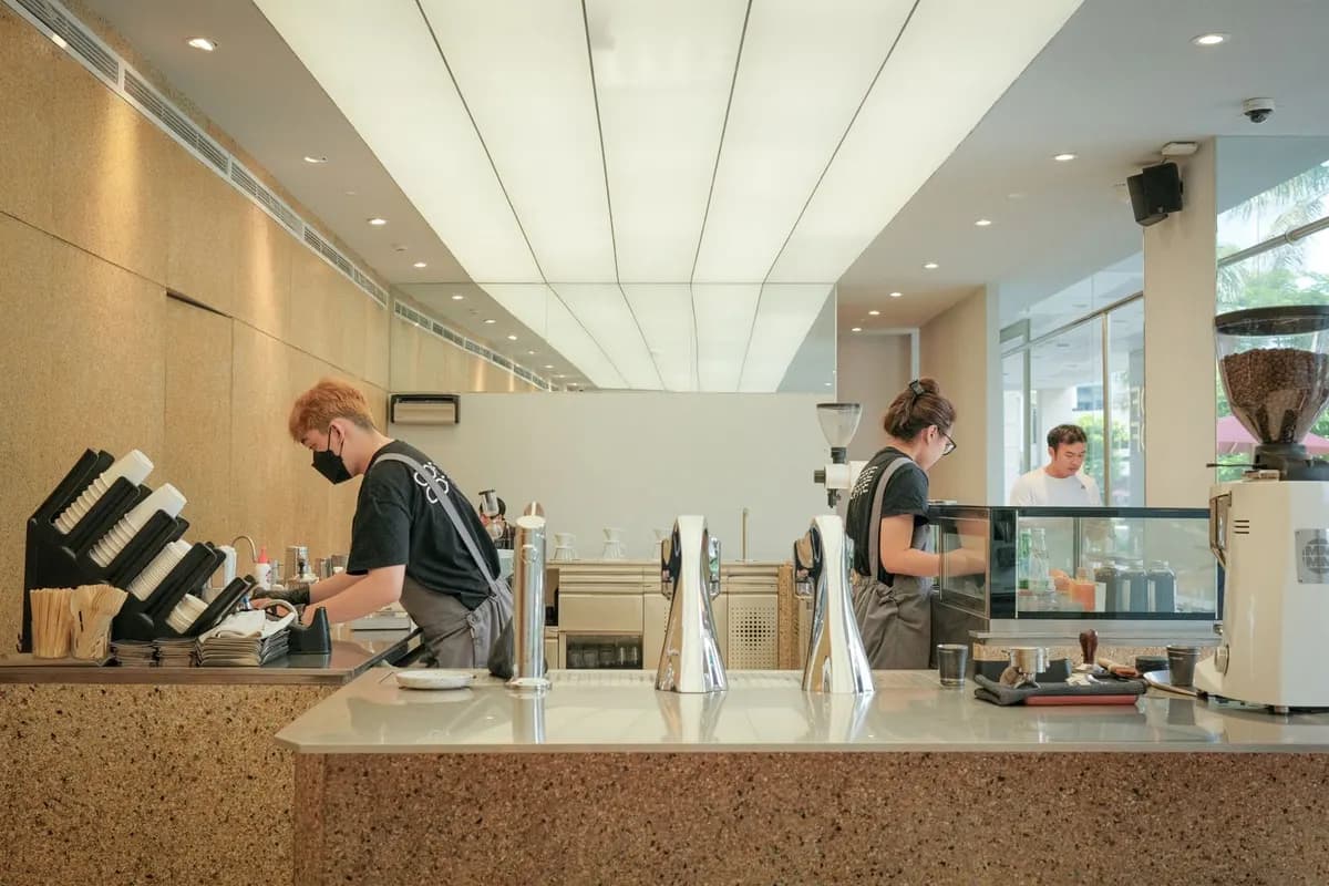 Baristas preparing coffee behind the counter of a bright, modern café